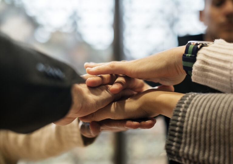 Diverse people stacking hands together